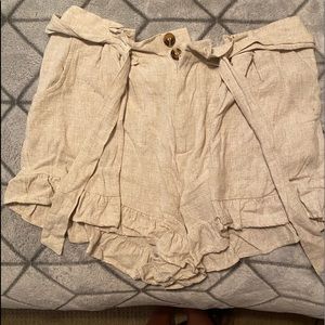 Tan shorts with buttons and a tie